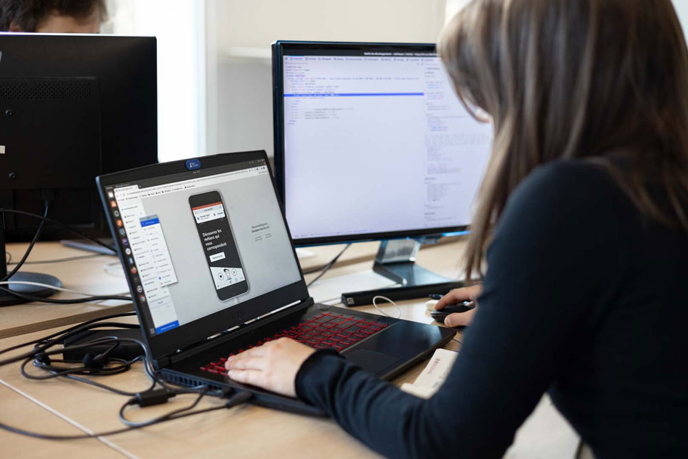 Image mise en avant - Anaïs, développeuse chez Fotetsa, en train de travailler sur une application mobile hybride depuis son laptop