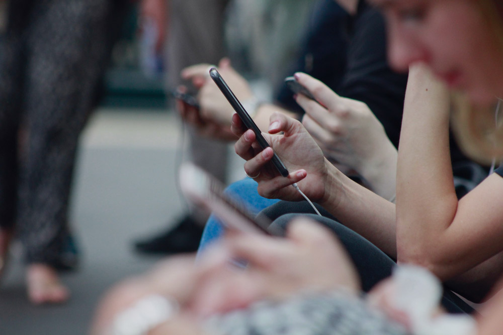 Image mise en avant - Plusieurs personnes assises regardant leurs téléphones